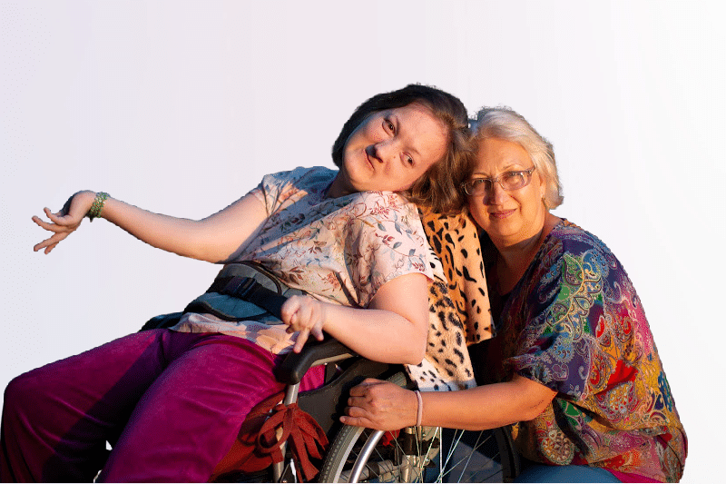 Disabled child in wheelchai with mother hugging.